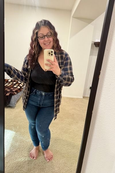 Mirror selfie of woman wearing a navy and tan striped shirt with denim jeans and the Knix Luxelift tank top bra underneath