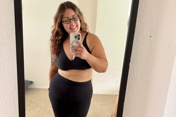 mirror selfie of woman wearing the black knix revolution bra and smiling at the camera