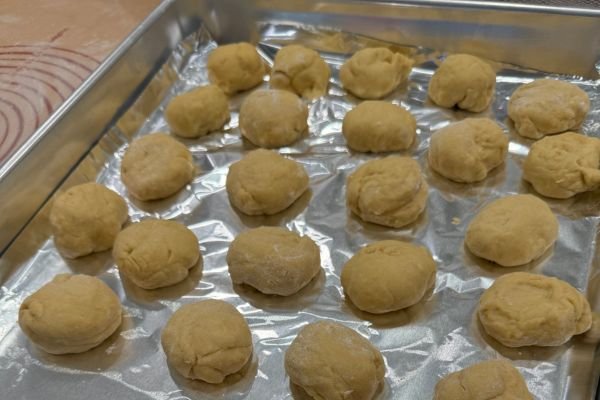 Image of smaller dough balls on a baking sheet lined with foil