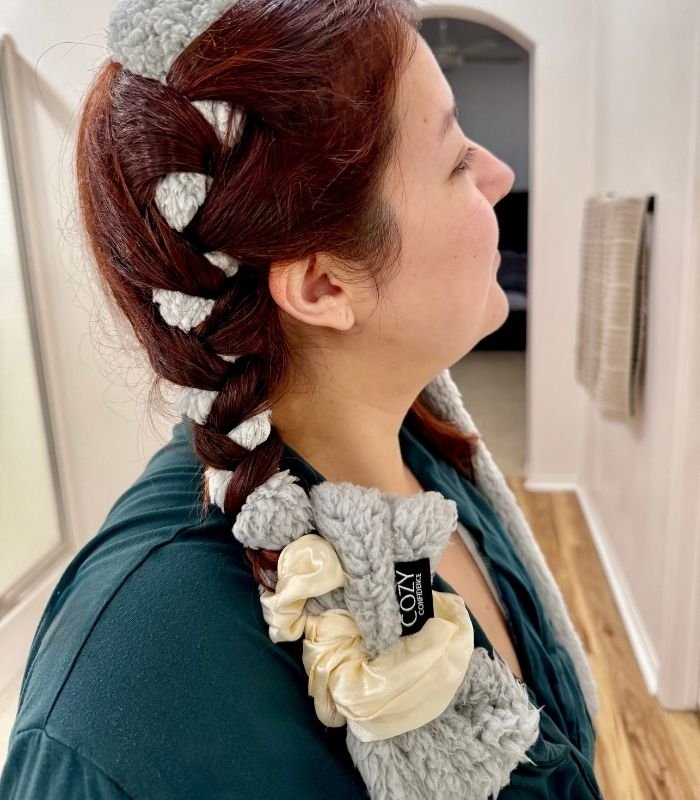 Cozy confidence curlband in grey being worn by woman in a dark green top